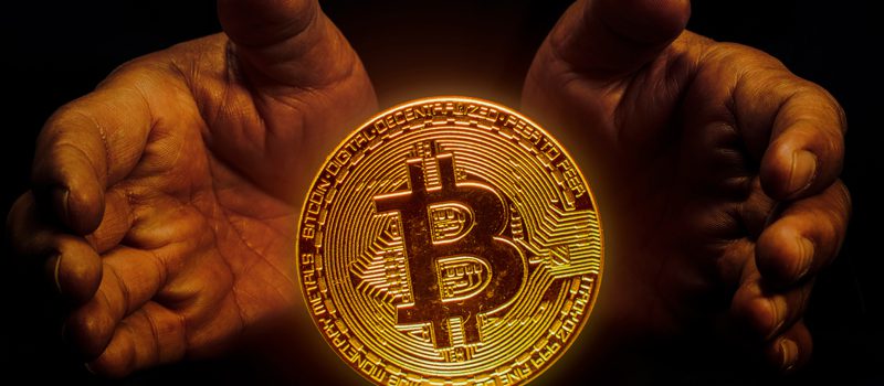 Mãos segurando moeda de bitcoin Mãos segurando moeda de bitcoin