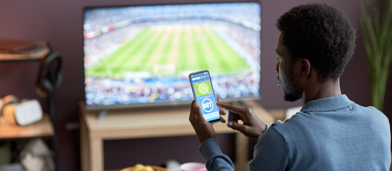 Homem apostando enquanto assiste ao jogo de futebol