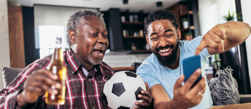 Pai e filho assistindo a jogo de futebol