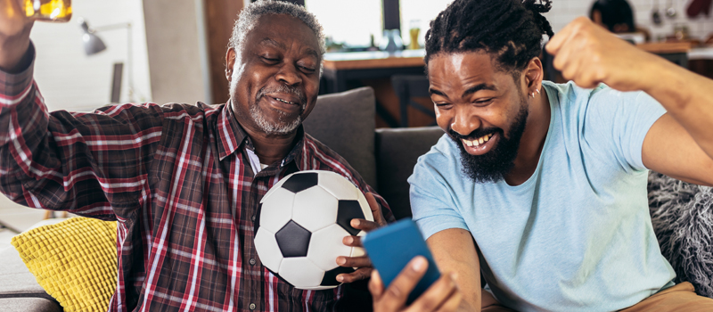 Pai e filho assistindo ao jogo de futebol juntos