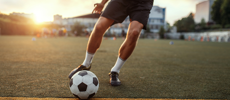 Jogador chutando bola de futebol